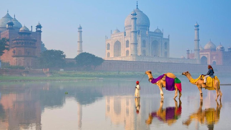 Penunggang unta dengan latar Taj Mahal