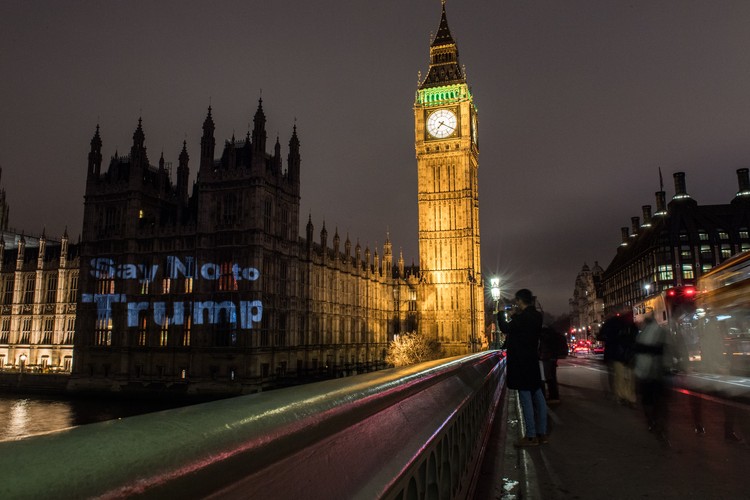 Ada yang terlihat berbeda dari Istana Westminster di London, Minggu (19/2). Gedung parlemen itu menjadi latar dari proyeksi bertuliskan Say No to Trump.