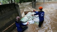 Tanggul yang jebol itu ditutup dengan karung berisi pasir.