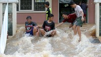 Sejumlah anak asyik bermain banjir.