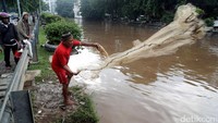 Seorang warga terlihat menjala ikan di kawasan Sungai Pasar Baru, Jakarta, Selasa (21/2/2017).