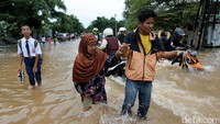 Sejumlah warga dan beberapa pengendara motor nampak melintasi banjir di kawasan Komplek Billymoon, Pondok Kelapa, Jakarta Timur, Selasa (21/2/2017).