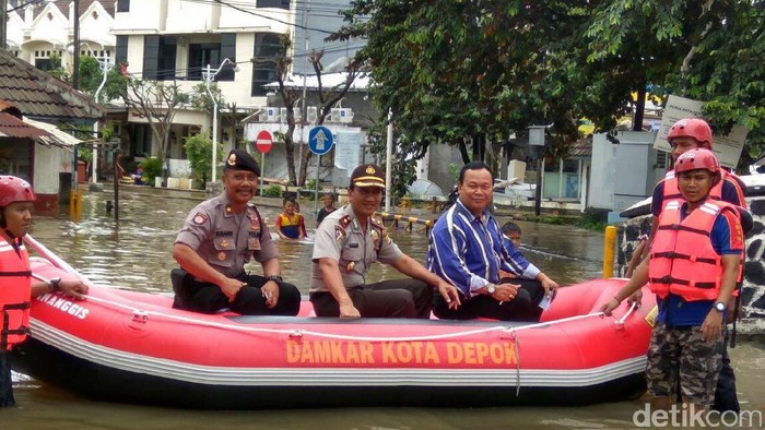 Polisi Bantu Seberangkan Warga yang Terdampak Banjir di Depok