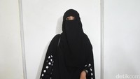 Ia pun tampil bercadar dengan busana serba hitam. Pool/Noel/detikFoto.