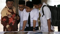 Para pelajar melihat pameran ini.