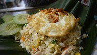 Nasi goreng gaya kampung dibuat dengan irisan cabai rawit, suwiran ayam dan topping telur mata sapi setengah matang.