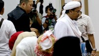 Habib Rizieq yang mengenakan pakaian serba putih memasuki ruang sidang.