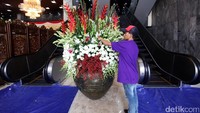 Pekerja memasang bunga di depan eskalator gedung DPR, Rabu (1/3/2017).