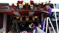 Pekerja menghiasi pintu masuk ke gedung.