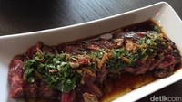 Porsi Churrasco Style Wagyu begitu besar. Lembaran wagyu dalam tingkat kematangan rare ini dipadukan saus ponzu, chimichurri, dan bawang merah goreng.