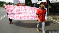 Massa membawa spanduk tuntutan.