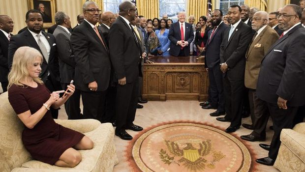 Kellyanne Conway duduk berlutut di atas sofa Ruang Oval Gedung Putih