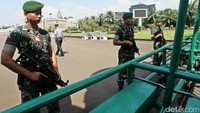Prajurit TNI bersenjata lengkap berjaga di gerbang gedung DPR.