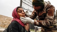 Pasukan militer Irak nampak memberikan pertolongan pertama kepada seorang wanita yang juga terkena serangan mortir saat perang antara pasukan militer Irak dan ISIS berlangsung. REUTERS/Zohra Bensemra.