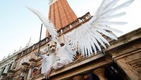 Salah satu peserta yang mengenakan kostum secara maksimal. Dalam balutan pakaian bersayap putih dan topeng singa, peserta ini tampak seperti makhluk dalam dongeng (Reuters)