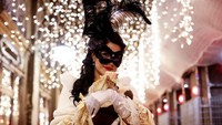 Selain peserta yang mengenakan topeng tanpa ekspresi, terselip peserta lain yang tidak menutupi seluruh wajahnya dengan topeng. Cantik dan anggun ya (Reuters)