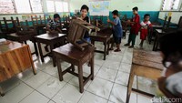 Para siswa membantu membersihkan sekolahnya.
