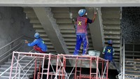 Tiga orang pekerja merampungkan renovasi tangga stadion.