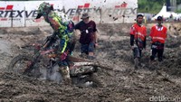 Seorang pebalap berusaha keluar dari jebakan lumpur.