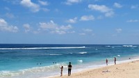 Foto: Wisatawan yang datang umumnya berenang di tepi pantai sambil terombang-ambing ombak. Ada juga mereka yang khusus membawa papan seluncur untuk bercengkrama dengan ombak Pantai Melasti yang apik (Ardan/detikTravel)