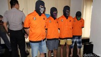 Para tersangka dihadirkan dengan memakai penutup kepala. Mereka juga memakai baju tahanan.