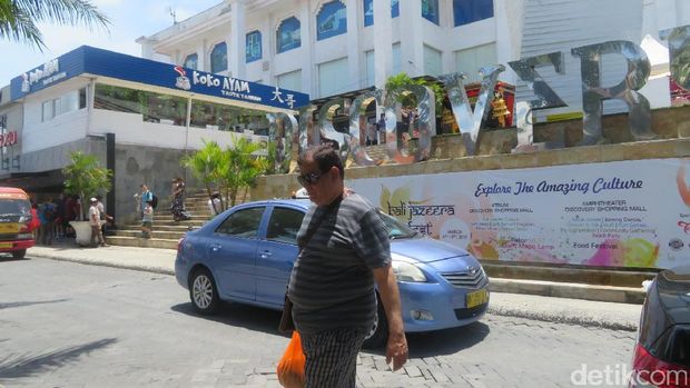 Dua orang dari rombongan Raja Salman jalan siang di mal di Kuta.