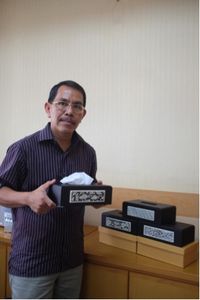 Zulfian, salah seorang pelaku UMKM binaan Telkom dengan brand  V&V Craft berpose bersama produk kerajinan kotak tisu miliknya.
