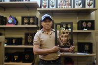 Pelaku UMKM Catur Batik Wood, Catur Sugiyono berpose bersama produk kerajinan topeng batik kayu di salah satu outlet handycraft Batik Wood di kawasan Thamrin, Jakarta.