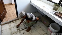 Pekerja memasang lantai dapur Rusun Marunda.