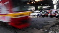 Pengendara menunggu Commuter Line melintas di Perlintasan Kereta Api di Jl TB Simatupang, Jakarta, yang akan ditutup.