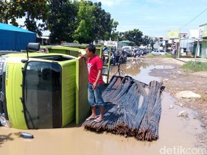 Terjerembab Lubang Jalan di Karawang, Truk Pengangkut Besi Terguling