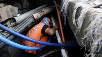 Petugas masuk ke dalam gorong-gorong di perempatan Fatmawati, Jakarta Selatan, Jumat (10/3).