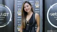 Ia tampil dengan jumpsuit hitam bergaris putih.
