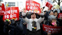 Dari kalangan yang memprotes Park Geun-Hye, mereka meneriakkan slogan anti-Park dan melambaikan bendera Korsel. Raut wajah tegang terlihat saat ketua hakim konstitusi Lee Jung-Mi membacakan putusan. Pembacaan putusan itu disiarkan secara langsung dengan layar besar di luar gedung mahkamah. Televisi-televisi Korsel juga menayangkan langsung pembacaan putusan yang sangat ditunggu-tunggu itu. REUTERS/Kim Hong-Ji.