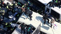 Polisi mengamankan pendukung Park yang menaiki atap bus. Pool/Kyodo/Reuters/detikFoto.