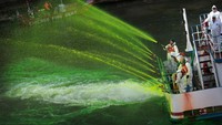 Petugas terlihat menyemprotkan pewarna khusus ke sungai selama perayaan St. Patricks Day. Scott Olson/Getty Images.