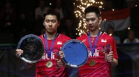 Kevin Sanjaya Sukamuljo (kanan) dan Marcus Fernaldi Gideon (kiri) menunjukkan trofi usai mengalahkan Li Junhui/Liu Yuchen di final All England 2017 yang dihelat di Barclaycard Arena, Minggu (12/3/2017) malam WIB. (Pool/Andrew Boyers/Reuters/detikFoto)
