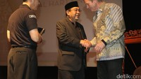 Harry Azhar Azis berjabat tangan dengan Deputi Direktur USAID Office For Democracy, Right, and Goverment Kevin McGrath usai membuka Festival Film Kawal Harta Negara 2017.