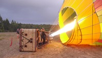 Balon ini diisi dengan udara yang dipanaskan oleh mesin pemanas bertenaga gas. Tampak nyala api menyambar-nyambar. Awas, jangan dekat-dekat ya traveler! (Wahyu/detikTravel)