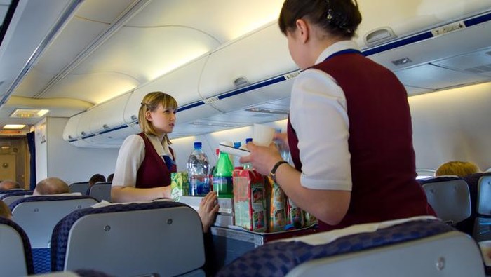 Man eating sandwich in economy class in airplane