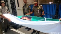 Satpol PP menurunkan spanduk dan alat peraga kampanye (APK) Pilkada DKI Jakarta.