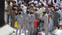 Petugas cleaning service membersihkan lantai di dekat Hajar Aswad. Sementara polisi meminta para jamaah untuk mundur. Pembersihan lantai dilakukan jelang salat (Fitraya/detikTravel)