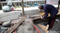 Seorang warga mendirikan bangunan di lokasi gusuran.