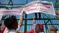 Para perawat memasang spanduk di gerbang Gedung DPR.