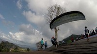 Seorang peserta lepas landas saat kejuaraan Paralayang TROI 2016, di Gunung Tumpa, Manado, Sulawesi Utara. Pool/Okke Gania.
