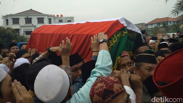 Para pelayat berebut memegang peti jenazah KH Hasyim Muzadi