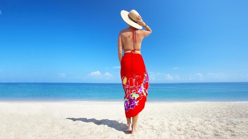 Sandy toes and feet of two women relaxing on chaise lounge chairs while enjoying a tranquil beach vacation. Idyllic Tropical beach resort scene of two women sunbathing