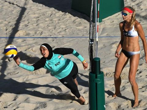 Egypt's Doaa Elghobashy (L) dives for the ball during the women's beach volleyball qualifying match between Canada and Egypt at the Beach Volley Arena in Rio de Janeiro on August 11, 2016, for the Rio 2016 Olympic Games. / AFP PHOTO / Yasuyoshi Chiba