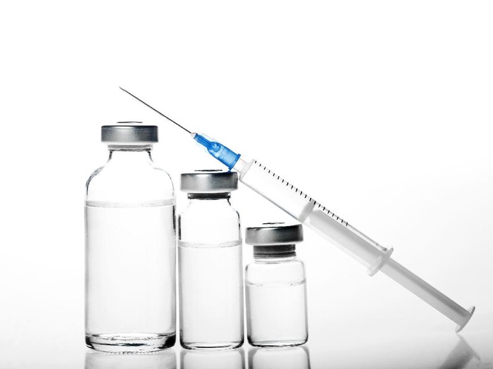 Beautiful young woman gets beauty injection in forehead from sergeant. Isolated over white background.