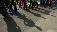 Para pekerja akan berbaris menurut mandor mereka masing-masing.